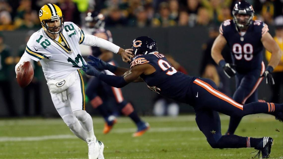 Green Bay quarterback Aaron Rodgers (12) tries to runs away from Chicago outside linebacker Leonard Floyd during Thursday’s game.