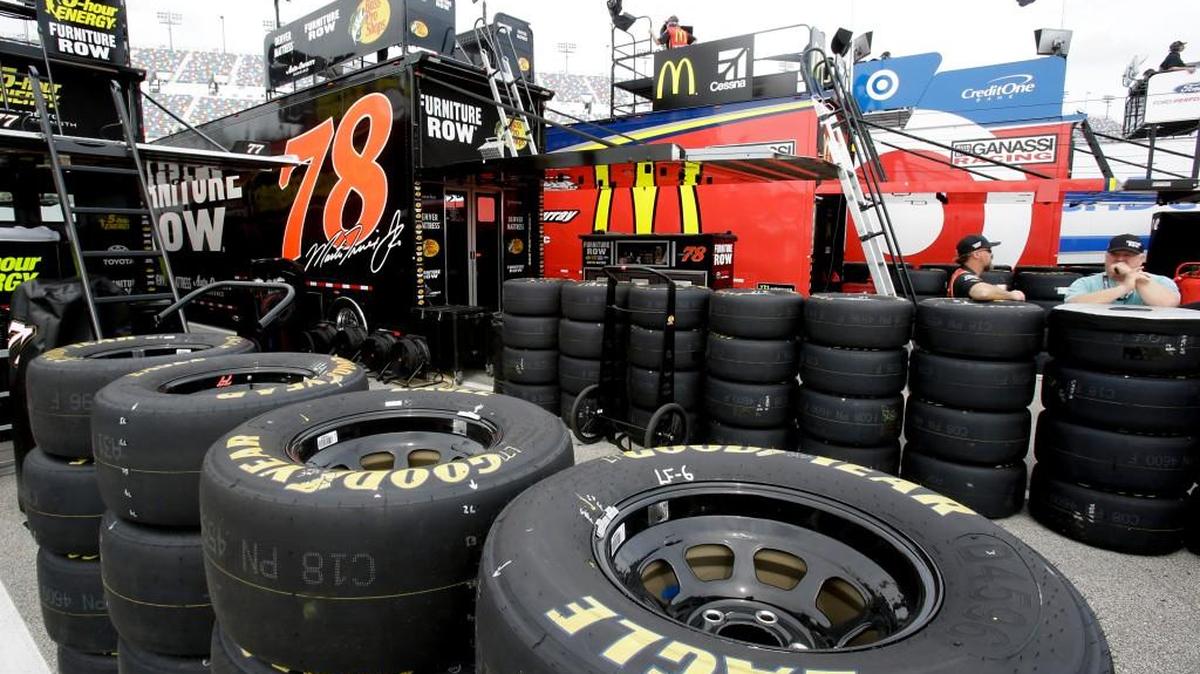 Tires for races cars are stacked outside the team haulers.
