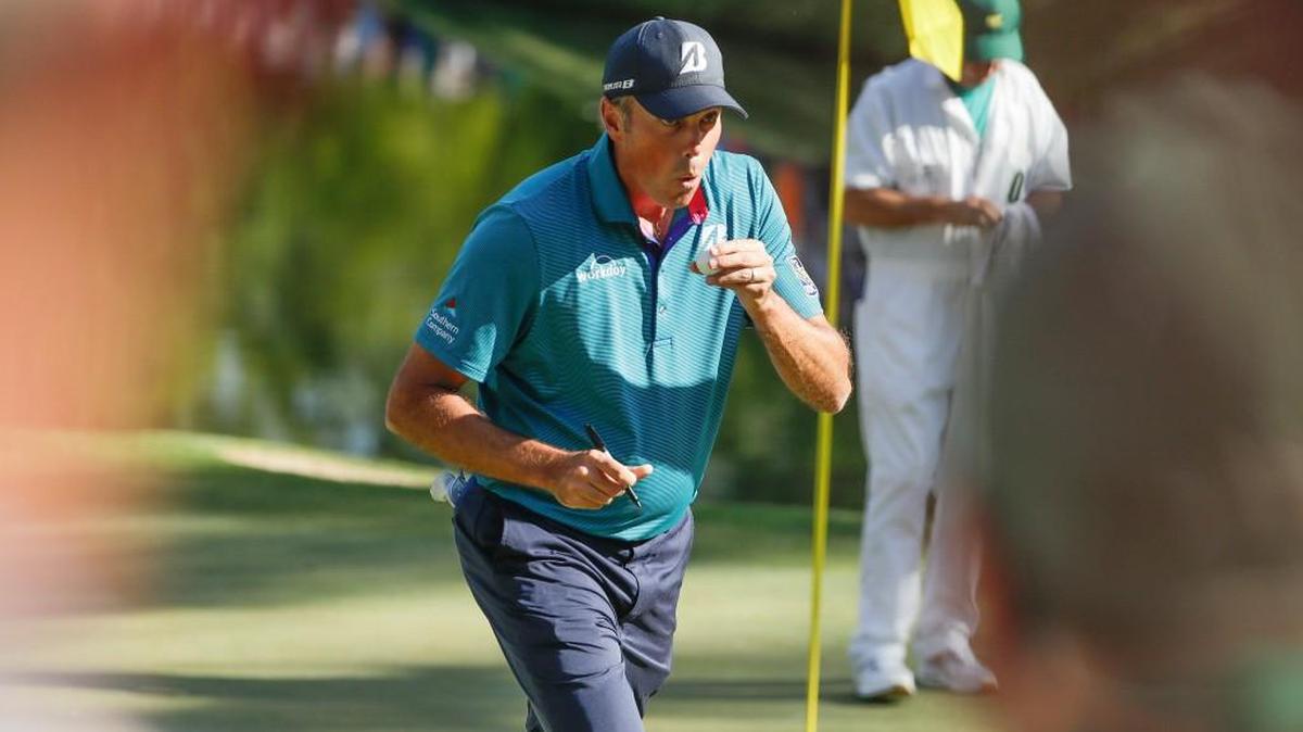Matt Kuchar blows on his ball after hitting a hole in one on the 16th hole during the final round of the Masters on Sunday.