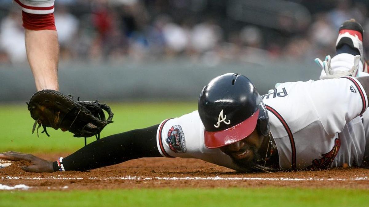 Atlanta’s Brandon Phillips dives back to first base during a baseball game against the Philadelphia Phillies on Tuesday.